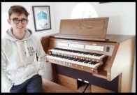 Organist William Fox sitting at his Viscount digital home practice organ