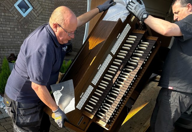 Viscount delivery team carefully lifting the Chorum 40 organ out of the delivery van.
